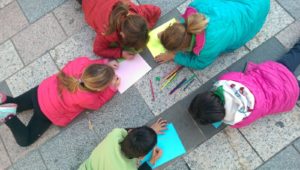 Children preparing a 20N activity in the floor of their village main square.
